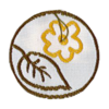 Rundes Abzeichen mit weißem Hintergrund und braunem Rand, darin befindet sich ein von Rand aus wachsendes Braunes Blatt und daneben eine stilisierte gelbe Blume.